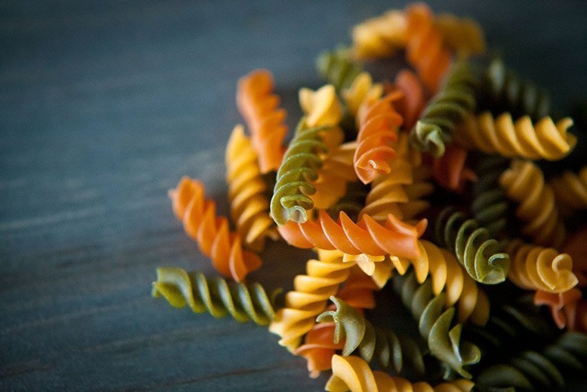 Photo of multicolor pasta on a wood table